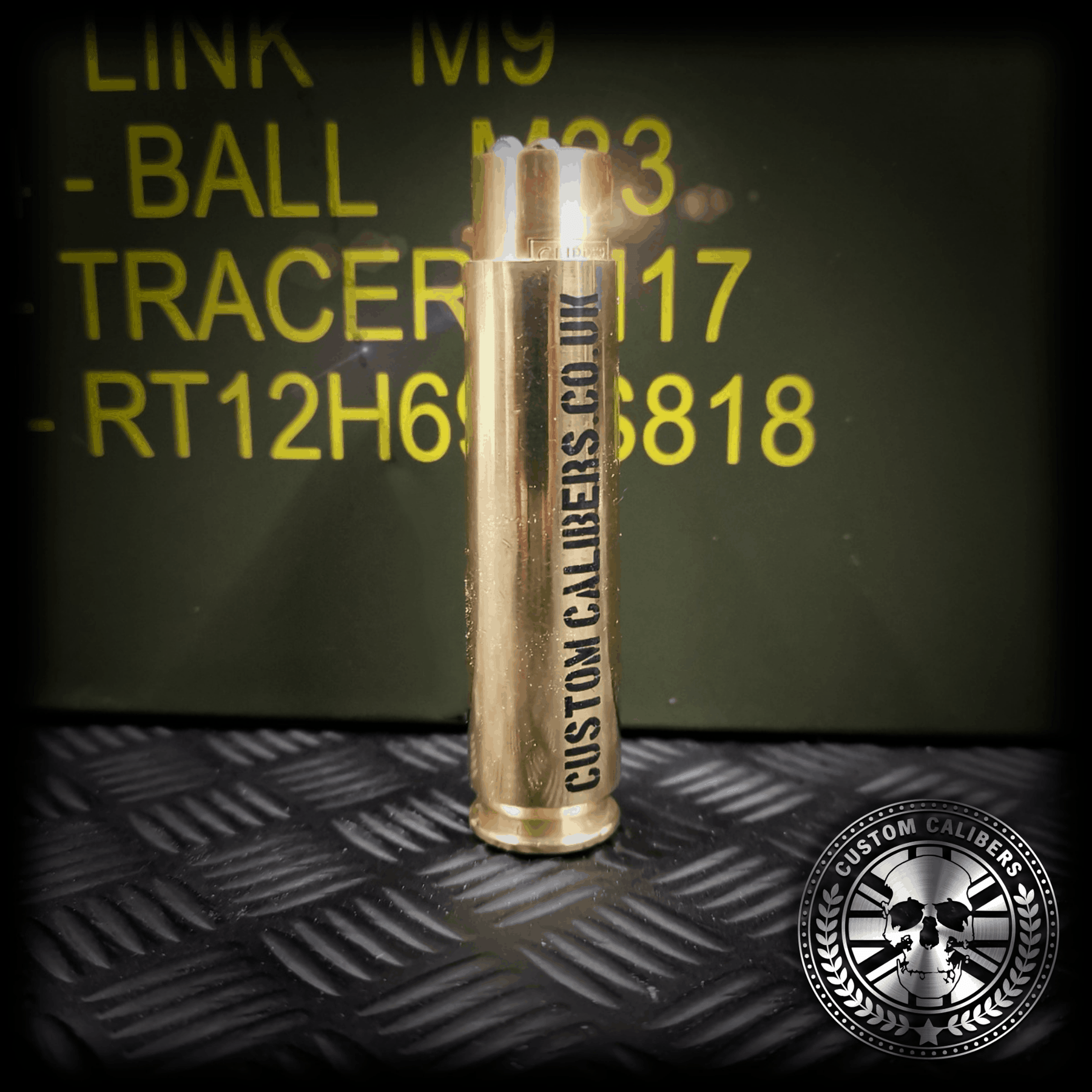 Acloseupshotofthepolishedbrass.caliberbulletclipperlighterwith"customcalibers.co.uk"engraveddownthelenghofthelighter