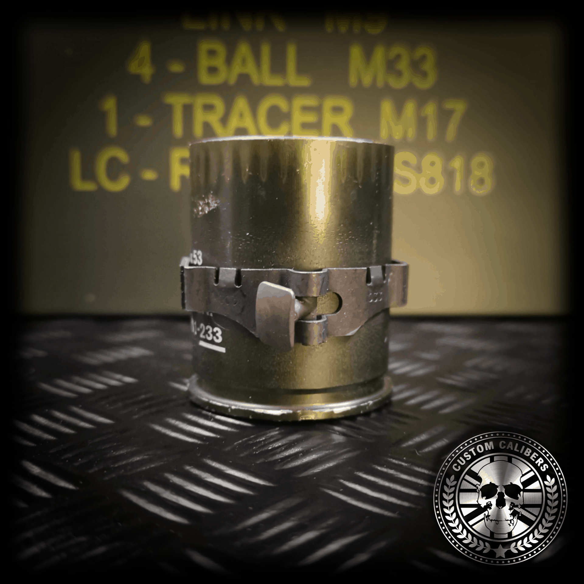 Acloseupshotoftheupcycledmmgrenadedrinkingshotglassshowingthelinkagearoundtheoutsideofthecasing