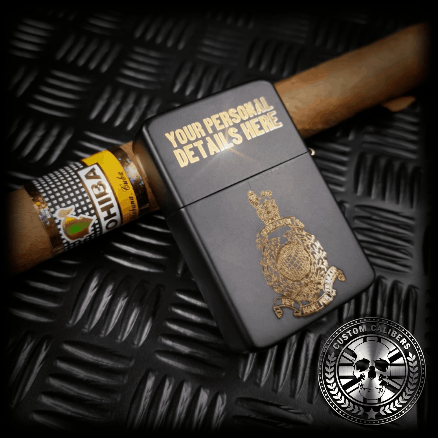 A matt black lighter with the lid open engraved with the royal marines crest resting on a cuban cigar