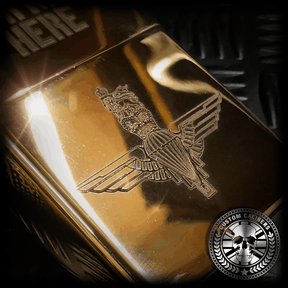 a close up of a gold coloured solid brass lighter engraved with the parachute regiment crest