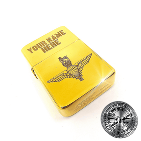 a close up shot of a polished solid brass flip top lighter engraved with the parachute regiments logo on the front