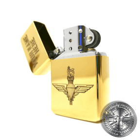 a close up shot of a polished solid brass flip top lighter with the lid open and engraved with the parachute regiments logo on the front