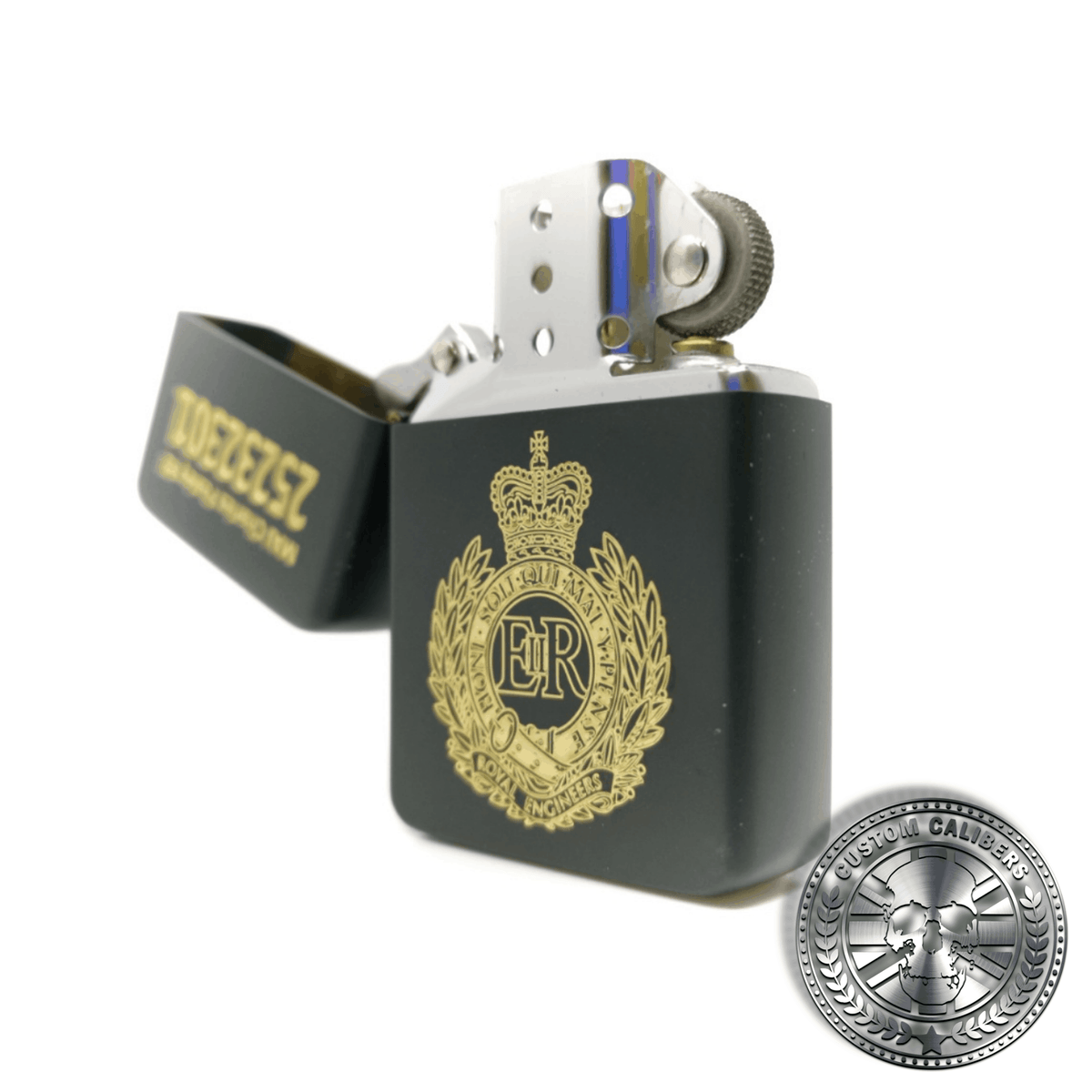 A close up shot of a matt black solid brass flip top lighter engraved with the royal engineers crest on the front with a name and military service number on the lid which has been opened to show the inside of the lighter