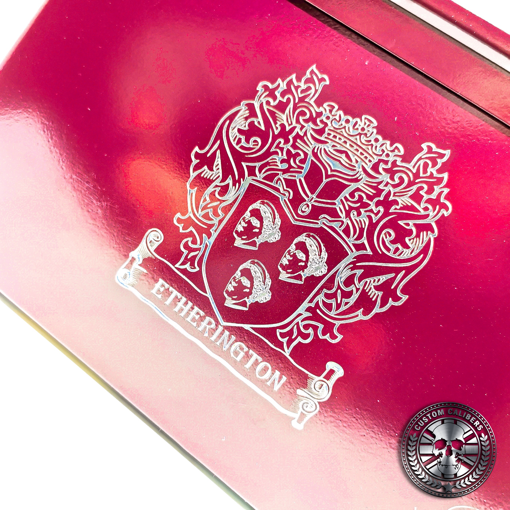 a close up photo of an engraved ammo tin powder coated in Airborne burgundy